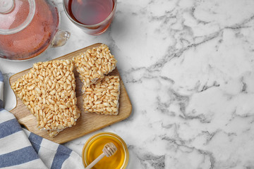 Delicious rice crispy treats on white marble table, flat lay. Space for text