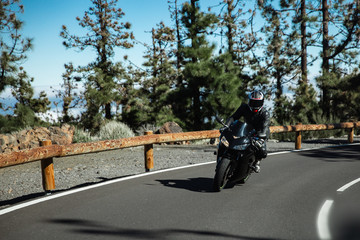 black motorcyclist on a mountain road.sports bike on a beautiful winding road