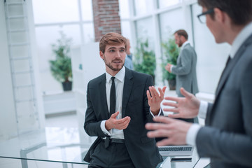 employees discuss their ideas standing in the office lobby