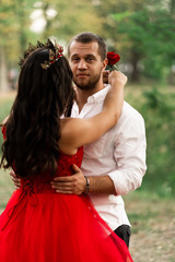 Wall Mural - Beautiful romantic couple kiss closeup. Attractive young woman in red dress and crown with handsome man in white shirt are in love. Happy Saint Valentine's Day. Pregnant and wedding concept.