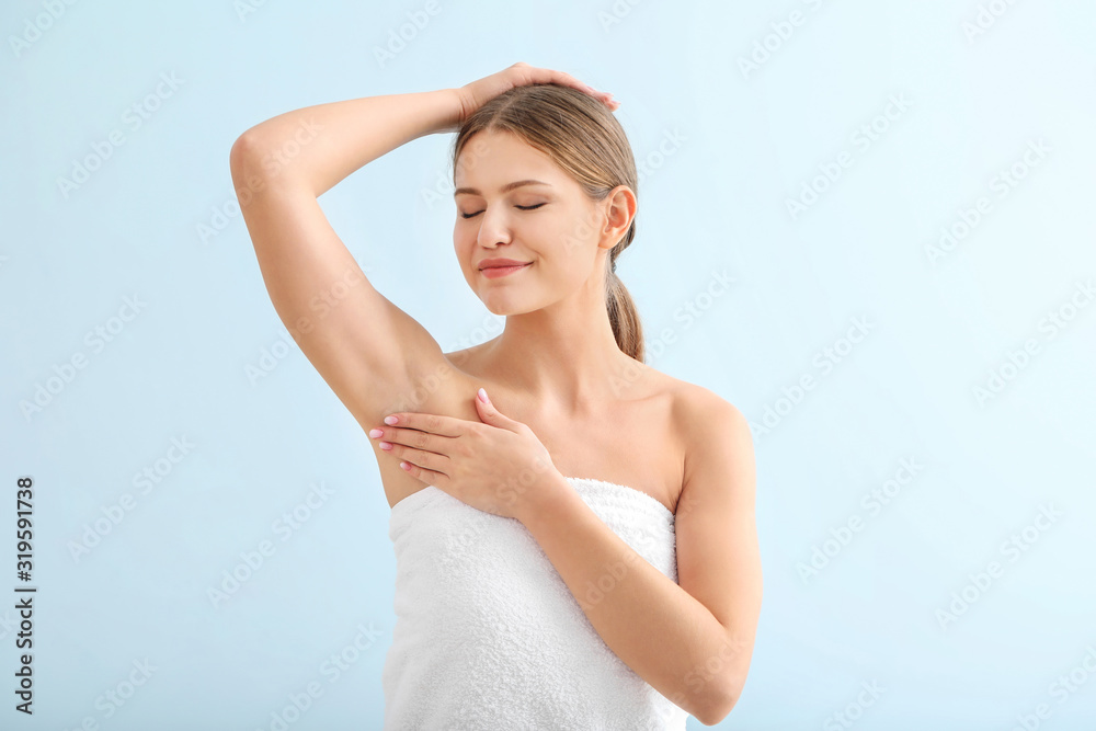 Beautiful young woman after shower on color background. Concept of using deodorant