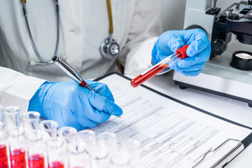 blood test tubes. senior female scientist examining blood test tubes at her laboratory dna testing