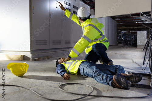 Wave to call out safety officer and Life-Saving Equipment,  Life-saving and rescue methods. Accident at work of electrician job or Maintenance worker in the control room of factory.