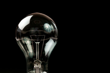 Incandescent light bulb on a black background