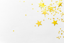 Gold Confetti And Stars And Sparkles On A Light Background. Top View, Flat Lay. Copy Text. Bright And Festive Background. For Christmas, New Year, Mother's Day.