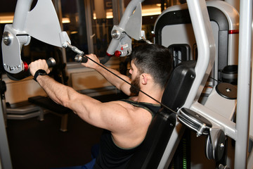 male athlete doing physical exercises in the sports gym