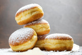 Fototapeta Zwierzęta - Close-up of donuts (Berlin pancakes) dusted with powdered sugar served on a rustic wooden table