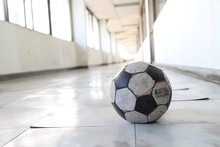 Abandoned Soccer Ball In Corridor Of Old School Building