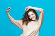 Portrait of a young beautiful woman wearing sweatshirt fooling around isolated over blue background