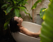 © Nejron Photo - Woman relaxing in outdoor bath with tropical leaves at Bali