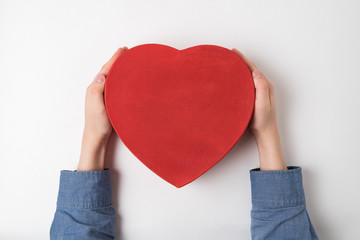 Wall Mural - Vintage style red heart shaped box in children hands isolated on white background