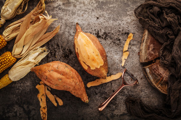 Wall Mural - top view of tasty healthy whole sweet potatoes and peeler on grey surface