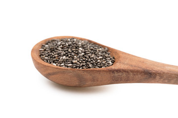 Brown wooden spoon with chia seeds seen obliquely from the side and isolated on white background