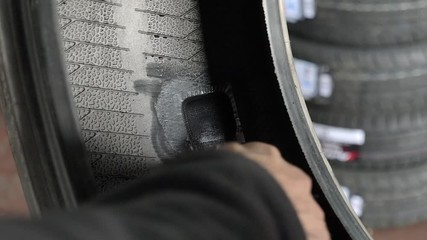 tire shop worker patching a flat tire.
