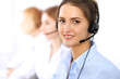 © rogerphoto - Call center. Focus on beautiful business woman using headset in sunny office