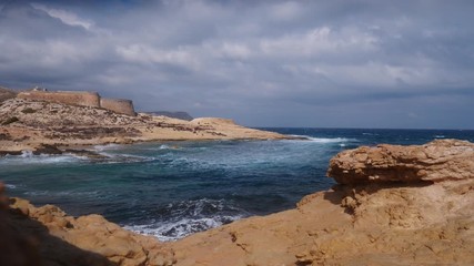 Sticker - Castle San Ramon above beach of El Playazo, Cabo de Gata, province Almeri­a, Andalusia Spain. Rocky sea shore with waves splashing in slow motion. Tourist site