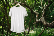 White Blank T-shirt For Mock Up Hanging On A Tree In Forest