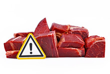 Concept For Antibiotics Residue And Harmful Bacteria In Meat For Human Consumption, Showing Chunks Of Red Meat With Yellow Warning Sign