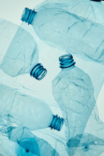 Empty Plastic Squashed Bottles Over Blue Background. Collecting Plastic Waste To Recycling. Concept Of Plastic Pollution And Too Many Plastic Waste. Copy Space For Text. Environmental Issue