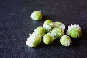 frozen green peas on a black background