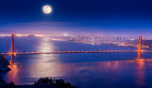 Illuminated Golden Gate Bridge Over Sea Against Full Moon At Night