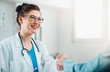 © Suteren Studio - Portrait of Smiling Woman Doctor shaking the hand of a patient. Doctor and Patient Handshake