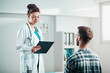 © Suteren Studio - Woman Doctor reads results to Young Patient