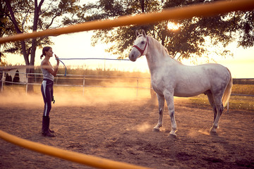 Wall Mural - Woman trainig her horse at sunset. fun on countryside,  golden hour. Freedom nature concept.