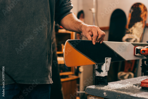 Fotomural cropped view of worker touching ski in repair shop