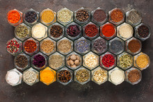 Different Kinds Of Spices And Herbs In Glass On Grey Background