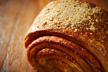 Sticker - Sweet cinnamon roll bread on wooden background 