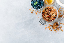Healthy Breakfast Granola With Fresh Blueberry And Honey On Gray Stone Background