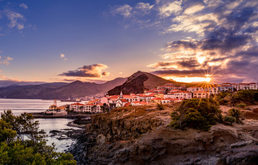 View on village with coastline during sunset with sun star