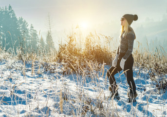 Happy female traveler resting on top of mountain under blue sky