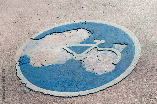 Fotografía Bicycle lane sign on the asphalt, deteriorated by time and use.