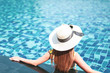 © structuresxx - Summer and vacation concept. Young woman in sun hat relaxing in swimming pool.