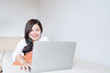 © PRIME STOCK LAB - Charming teenage lying on bed and watching tv or movies streaming on laptop.