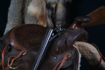 Vintage Shotgun with open Action Resting on Saddle