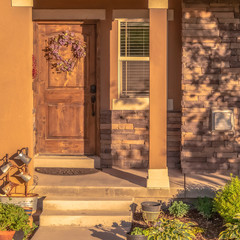 Square Home with pathway leading to gabled entrance of the front porch with brown door