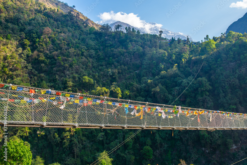 The suspension bridge named 'New Bridge' (278 m long) located nearly Jhinu Danda village, one of the famous village on the way to Annapurna Sanctuary of Nepal. - obrazy, fototapety, plakaty 