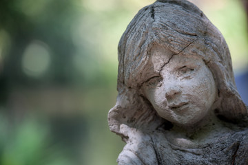 Cloes up photo of arden stone sculpture of a childern. Children statue.