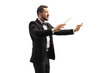 Male conductor in a suit conducting with a baton and gesturing with hand