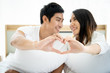 © DG PhotoStock - Funny and romantic Asian couple' portrait in bedroom with natural light from window, concept of relationship between husband and wife and being a family.