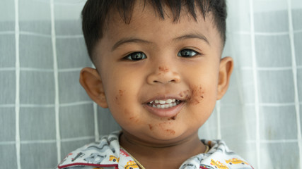 Wall Mural - Cute  little asian  baby boy eatting chocolate