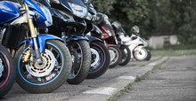 Motorcycles Standing In The Row On Asphalt Closeup. Selective Focus
