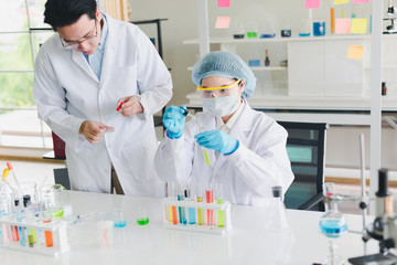 Asian scientists, men and women are helping to test and analyze various color chemicals in laboratories that have many scientific equipment.