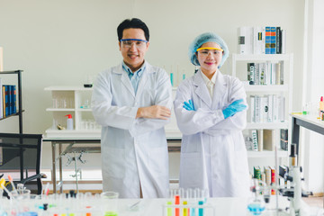 Asian scientists are preparing chemicals for testing and analysis in the laboratory. Scientists clear glasses and white shirts. Science and Chemistry Concept