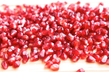 Sweet red clean sprinkled pomegranate berries look like pomegranate stones bright