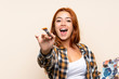 © luismolinero - Teenager redhead girl holding a palette over isolated background