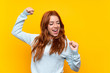 © luismolinero - Teenager redhead girl over isolated yellow background celebrating a victory